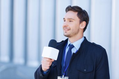 Journalist smiles while recording a newscast.