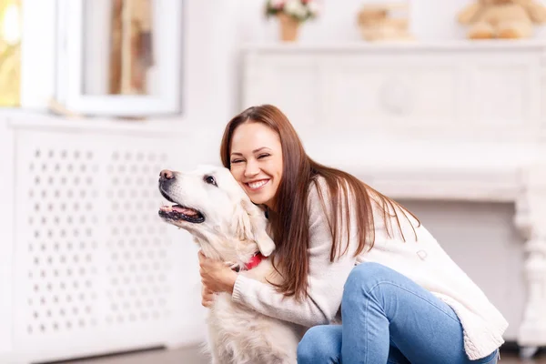 Schöne junge Mädchen umarmt ihren Hund fröhlich. — Stockfoto