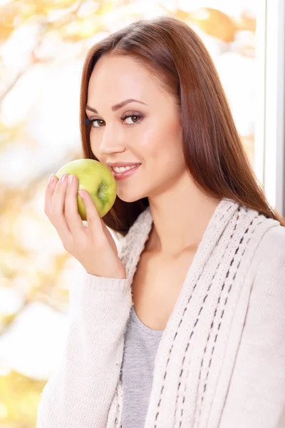 Joven chica sonriente está a punto de comer manzana . — Foto de Stock