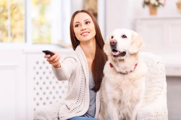 Young girl showing something to her dog on TV. — Stockfoto