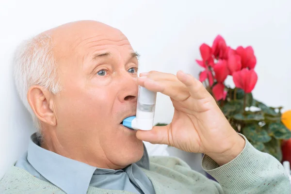 Hombre mayor de edad utiliza inhalador para curar su dolor . —  Fotos de Stock