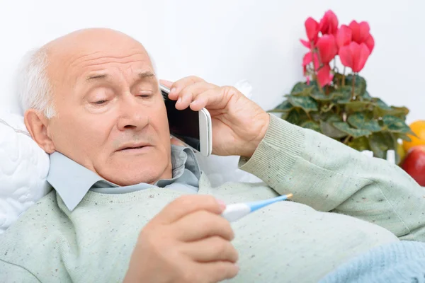 Despondent weary aged man calls up his relatives. — Stock Photo, Image