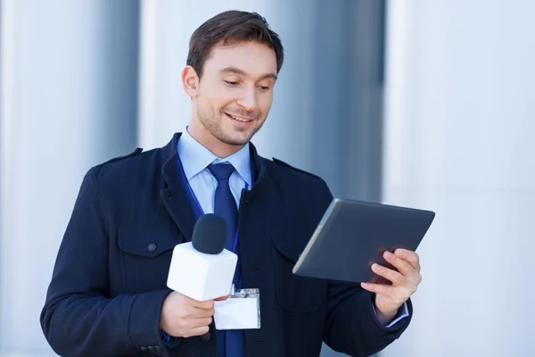 Newshawk is amused by information on his tablet. — Stockfoto