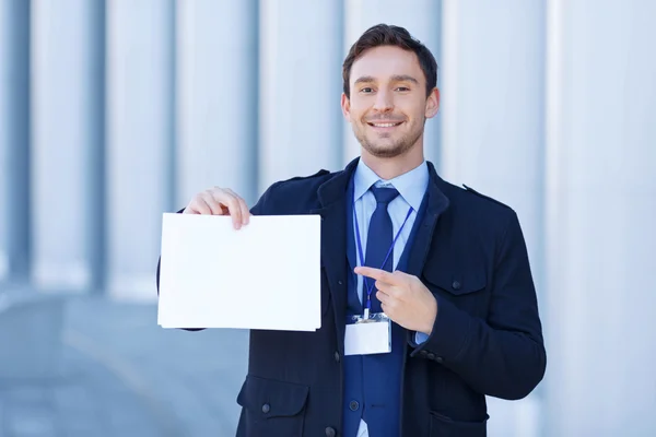 Smiling reporter points at sheet of paper. — Stock Photo, Image