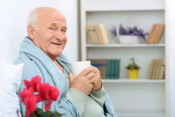 Elderly gentleman grins happily while resting. — Stock Photo, Image