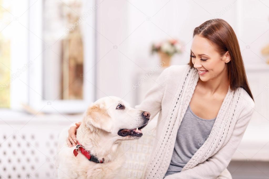 Attractive young girl is playing with her dog.