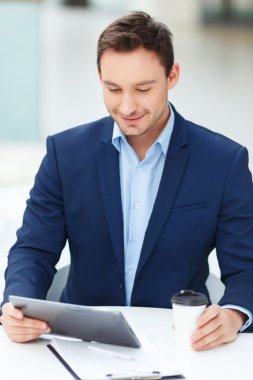 Genç beyefendi tablet ve papercup kahve ile.