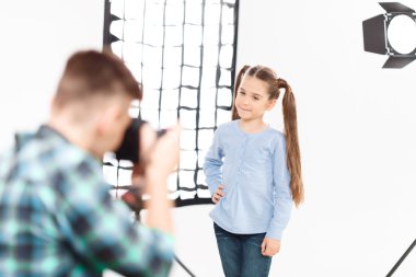 Little model poses when being photographed. clipart
