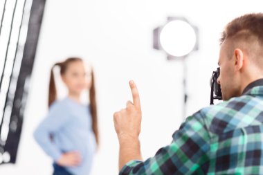 Male photographer asks a model to stand still.