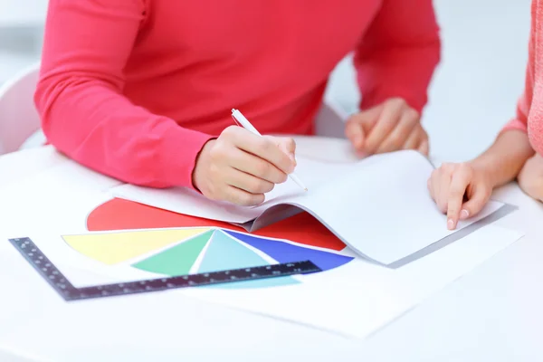 Two colleagues consulting over the writing pad. — Stock Photo, Image