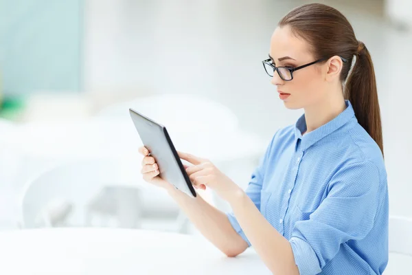 Vrouw zitten aan de balie en het gebruik van een Tablet PC — Stockfoto