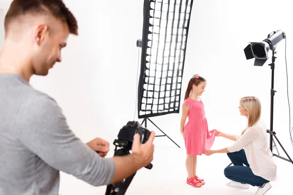 Fotografo controlla la sua fotocamera mentre il modello è in fase di preparazione — Foto Stock