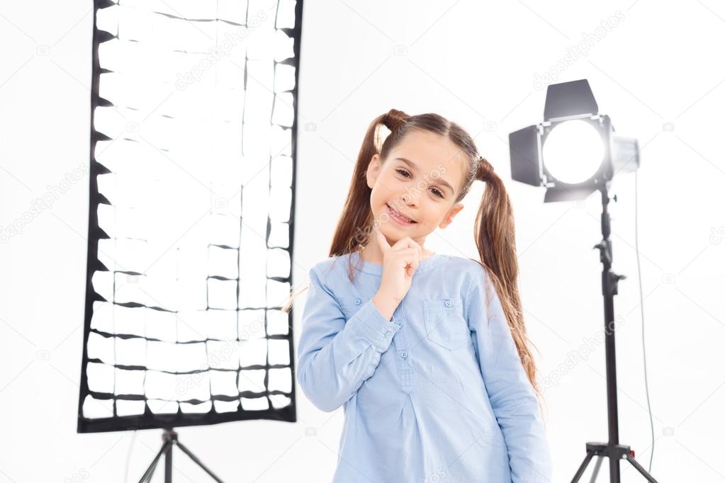 Little girl poses enthusiastically during photoshoot.