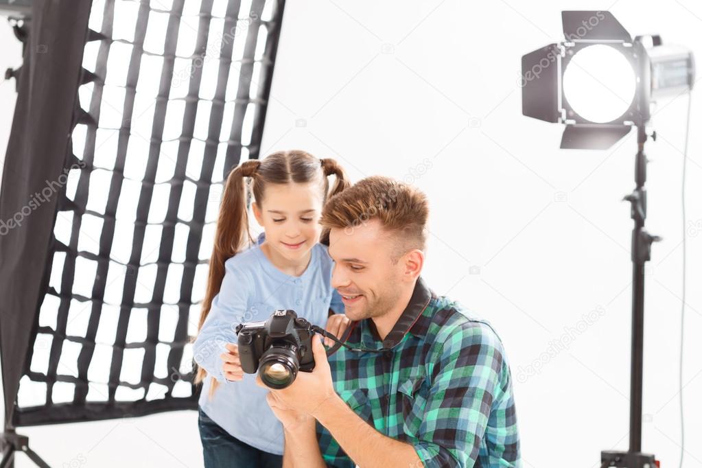 Photographer and little girl are reviewing the photos.