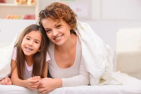 Moeder en dochter liggend op bed — Stockfoto