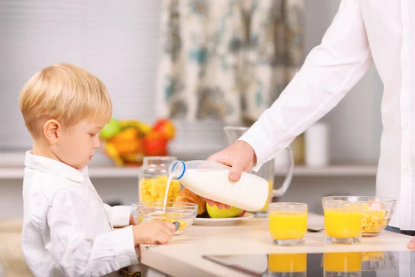 Papa gießt etwas Milch in die Schüssel. — Stockfoto