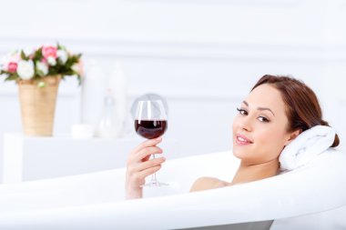 girl drinking wine while taking a bath