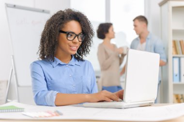 Female employee is working on the laptop.