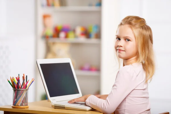 Niña está usando un portátil . — Foto de Stock