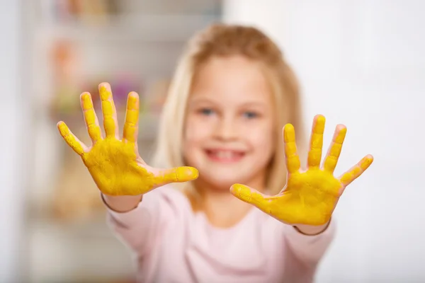 Mãos de criança cobertas de tinta amarela . — Fotografia de Stock