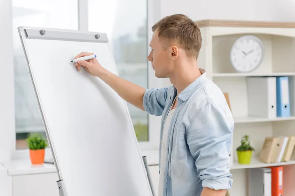 Male executive is writing on whiteboard. — Stock Photo, Image