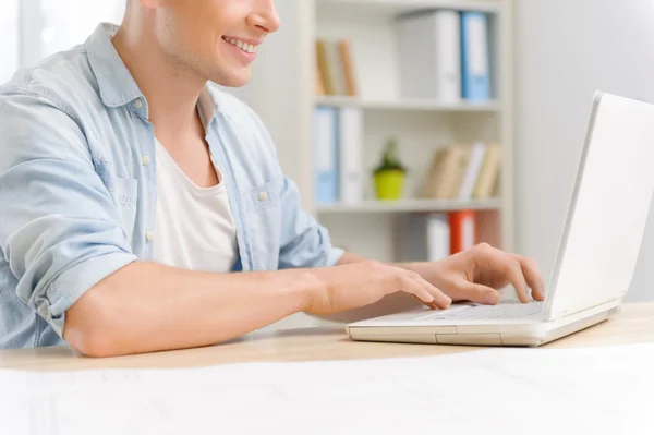 Jonge mannelijke werknemer werkt aan laptop. — Stockfoto