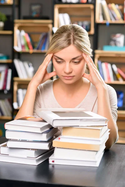 Jonge dame in de bibliotheek ziet er grondig moe. — Stockfoto