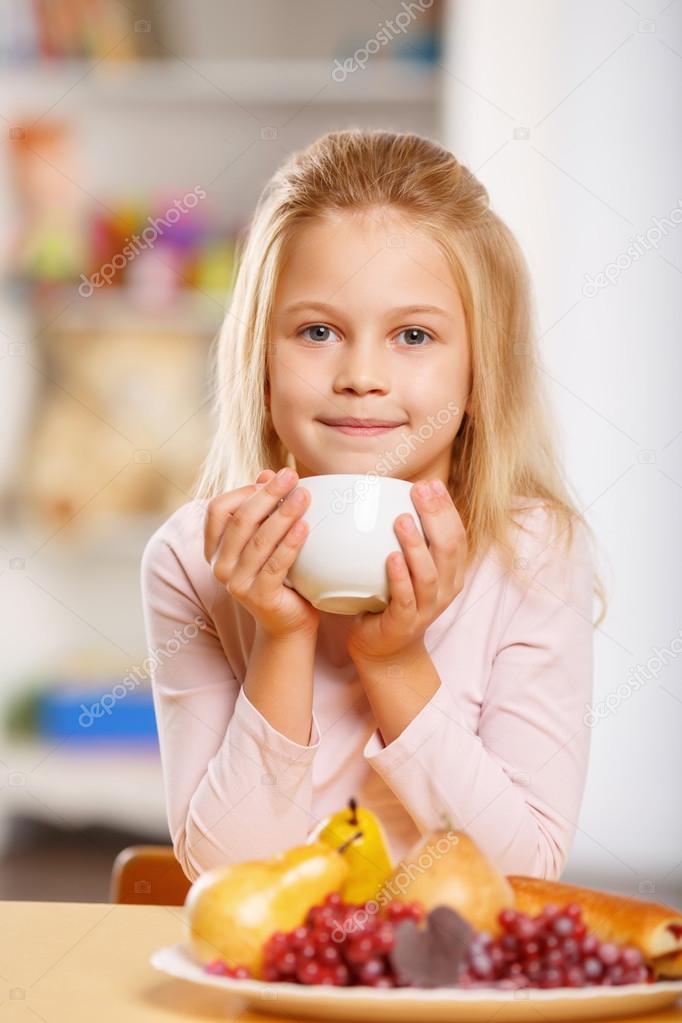 Little girl is drinking tea.