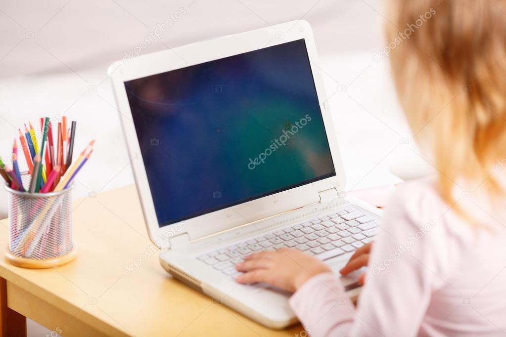 Child playing a game on laptop.