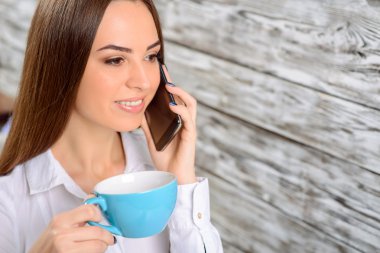 Kadın cep telefonuyla konuşuyor.