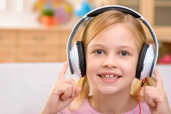 Vivacious little girl listening to music — Stockfoto