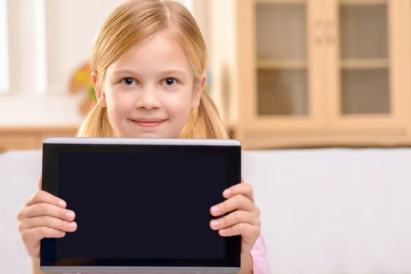 Joyful little girl holding tablet — Zdjęcie stockowe