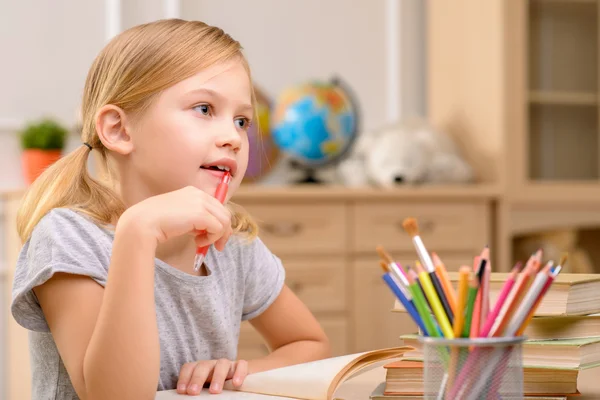 Hübsche Mädchen sitzen am Tisch — Stockfoto