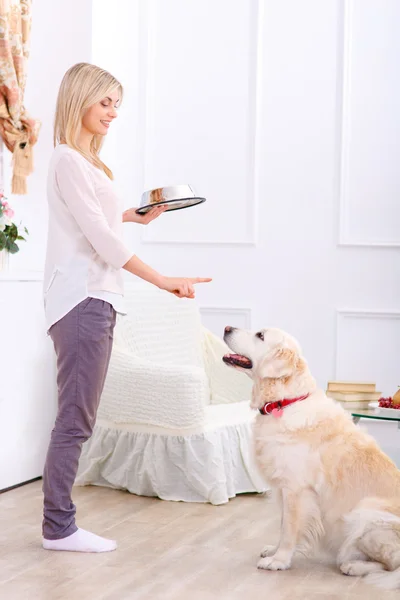 Mulher carinhosa alimentando o cão — Fotografia de Stock