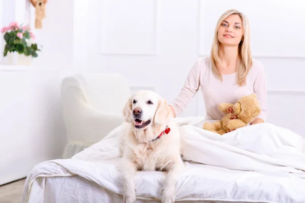 Donna premurosa sdraiata sul letto con il suo cane — Foto Stock