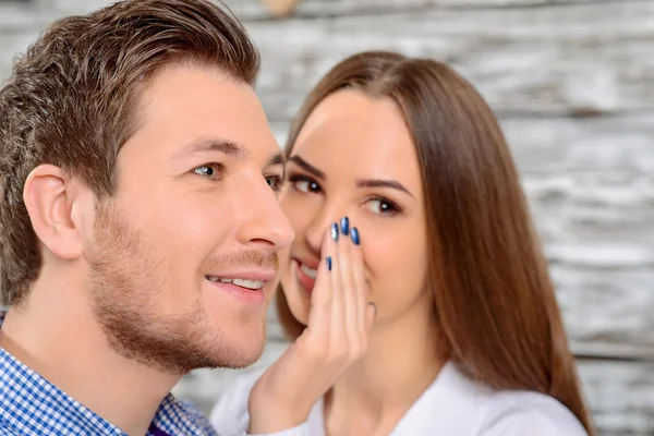 Woman whispering in the ear of her friend — Stok fotoğraf