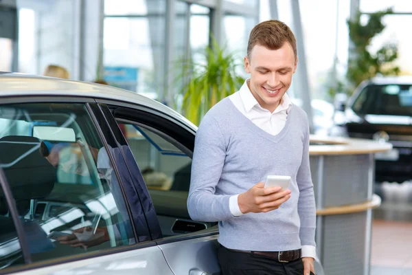 Pleasant man choosing car in auto show — Stock Photo, Image