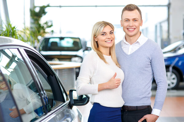 Happy couple going to buy a car