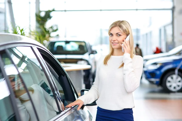 Nice woman choosing a car in auto show — Stock Photo, Image