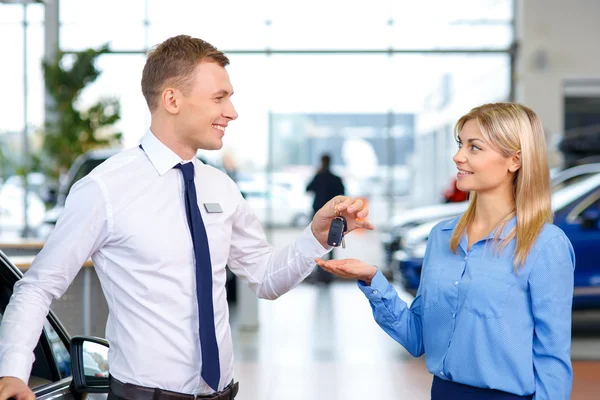 Assistant de vente donnant les clés de la voiture — Photo