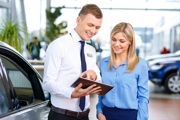 Sale assistant showing  tablet   to his colleague — Stock Photo, Image