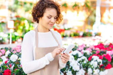 Onun smartphone kullanarak çiçekçi.