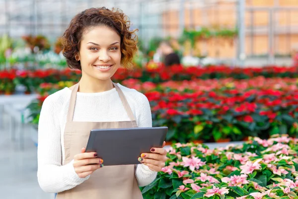 Florista sonriente sosteniendo una tableta . —  Fotos de Stock