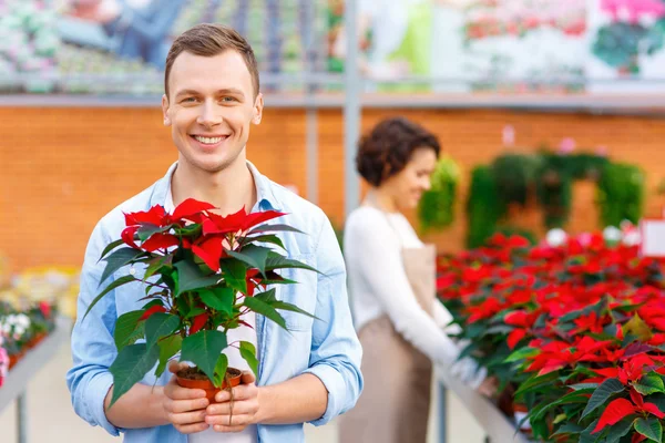 Potěšen zákazník drží květ. — Stock fotografie
