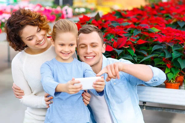 Familia joven tomando selfies en el invernadero — Foto de Stock