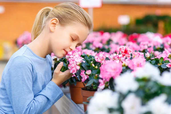 Niña inhalando olor a flor . — Foto de Stock