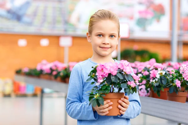Little girl holding a blooming flower. — Stock Photo, Image