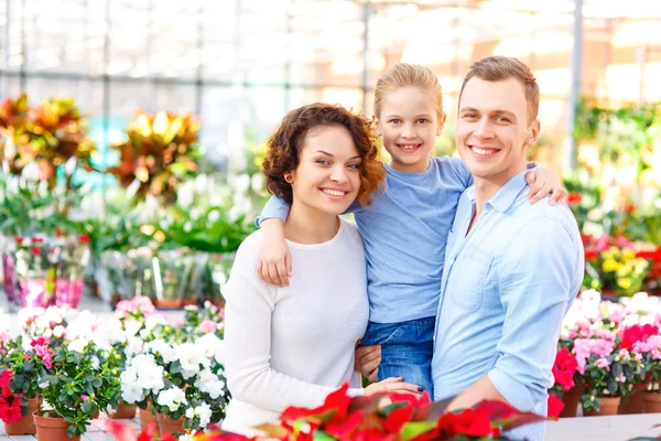 Young family in the greenhouse. — Stock Photo, Image