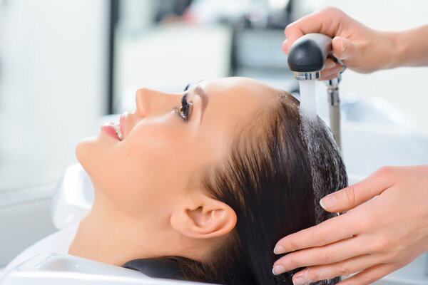 Stylist is washing clients hair.