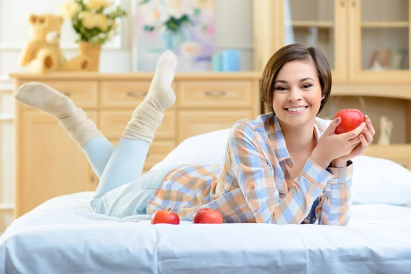 Joven chica sonriente posando con manzanas . — Foto de Stock